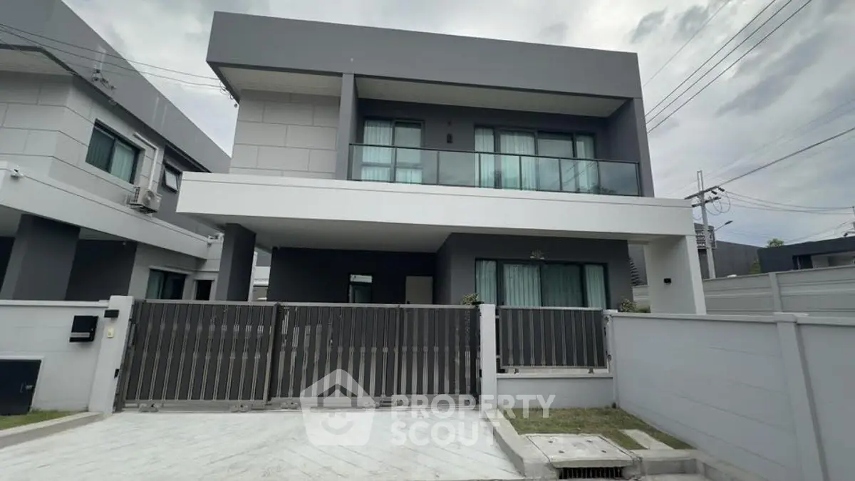 Modern two-story house with sleek design and spacious driveway in a suburban neighborhood.