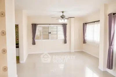 Spacious empty living room with large windows and ceiling fan, ready for customization.
