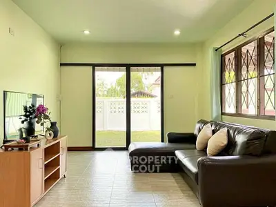 Spacious living room with modern decor and garden view, perfect for relaxation and entertainment.