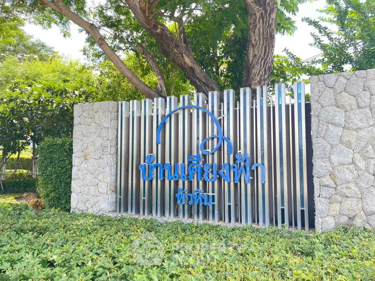Beautiful stone and metal entrance sign surrounded by lush greenery