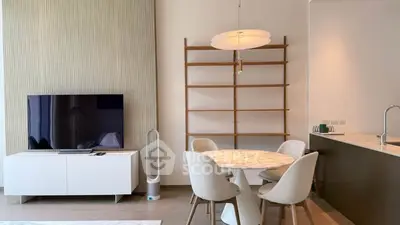 Modern living room with sleek TV, stylish dining set, and elegant decor