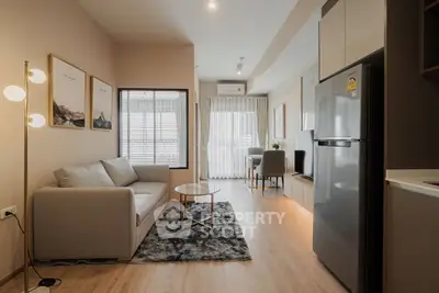 Modern living room with sleek furniture and natural light, featuring a cozy sofa and stylish decor.
