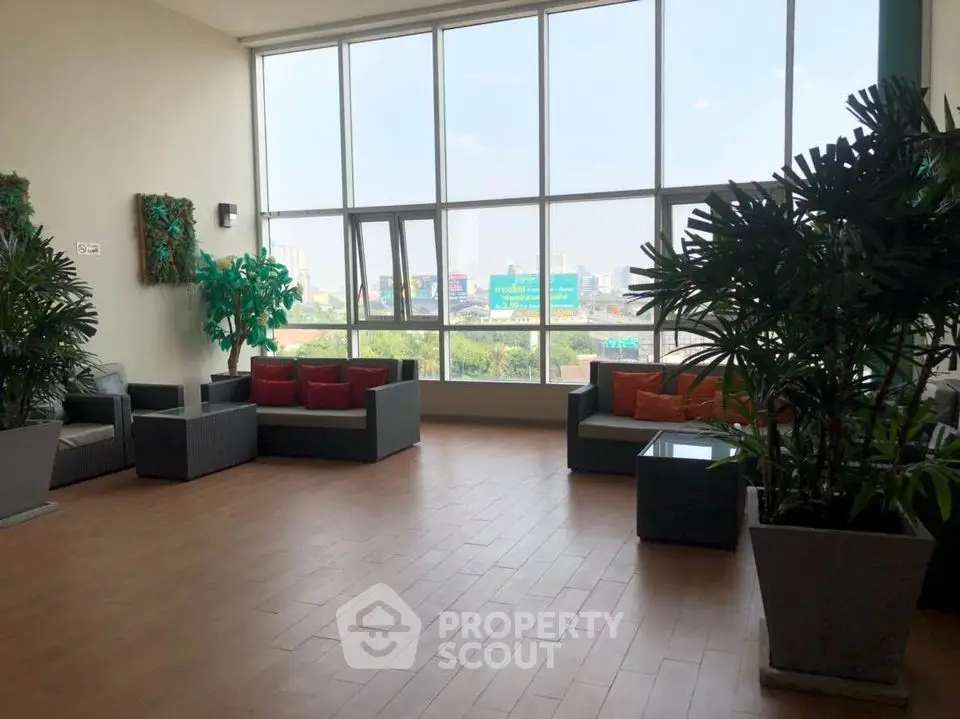 Spacious living room with large windows and modern decor, offering a bright and inviting atmosphere.