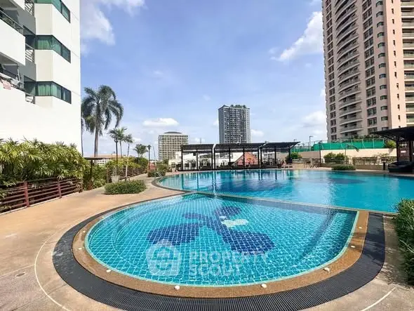 Luxurious high-rise apartment complex with stunning outdoor pool and city views.