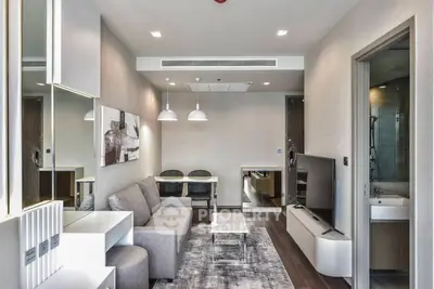 Modern living room with stylish decor and open layout, featuring a cozy sofa and sleek TV setup.
