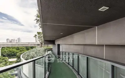 Modern curved balcony with glass railing and city view