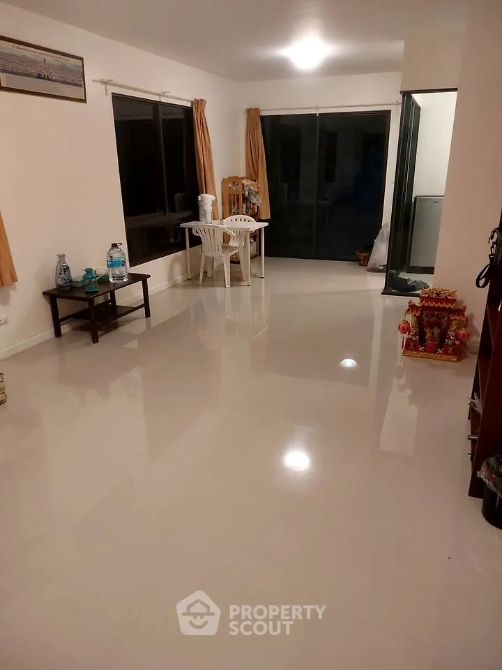 Spacious living room with glossy tiled floors and large windows