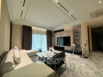 Luxurious modern living room with plush seating and large TV, perfect for relaxation and entertainment.