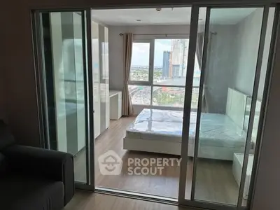 Modern bedroom with large windows offering a stunning city view, featuring sleek glass sliding doors.