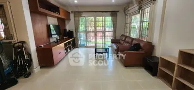 Spacious living room with modern furniture and large windows overlooking garden