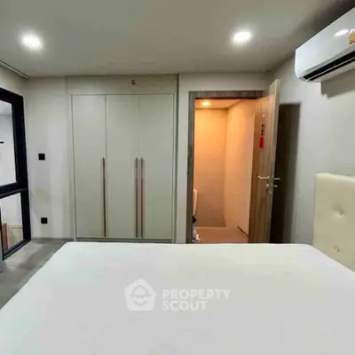Modern bedroom with built-in wardrobe and air conditioning unit