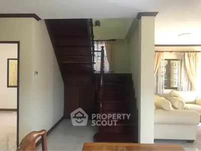 Charming interior with wooden staircase and cozy living area, perfect for family gatherings.