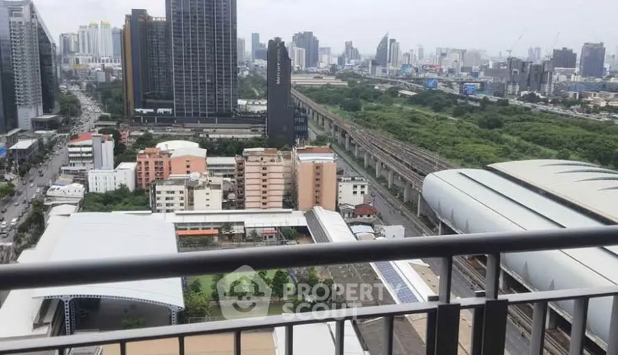 Stunning cityscape view from a high-rise balcony overlooking urban skyline and green spaces.