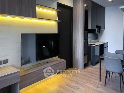 Modern living room with sleek wooden flooring and integrated kitchen design