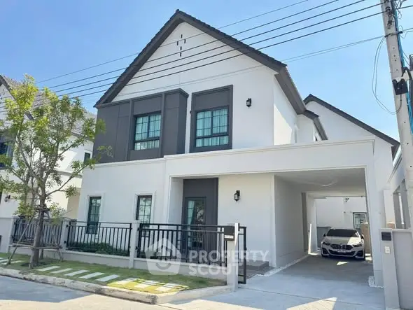 Modern two-story house with carport and sleek exterior design in a suburban neighborhood.