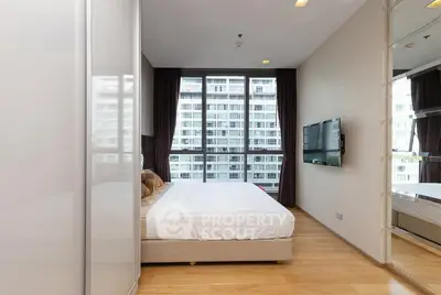 Modern bedroom with large window and city view, featuring sleek design and wall-mounted TV.