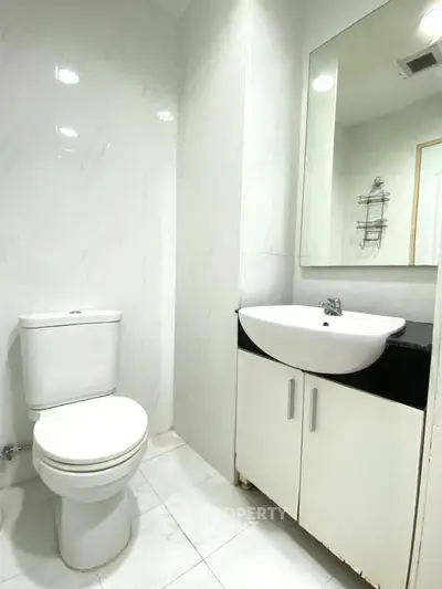 Modern bathroom with sleek white fixtures and elegant marble tiles.