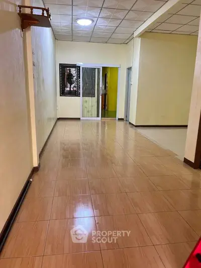 Spacious interior hallway with tiled flooring and neutral walls, ideal for versatile use.