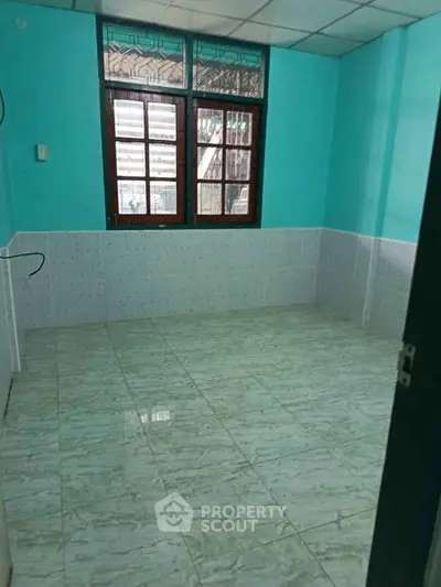 Spacious room with tiled flooring and large window, ideal for versatile use in a vibrant property.