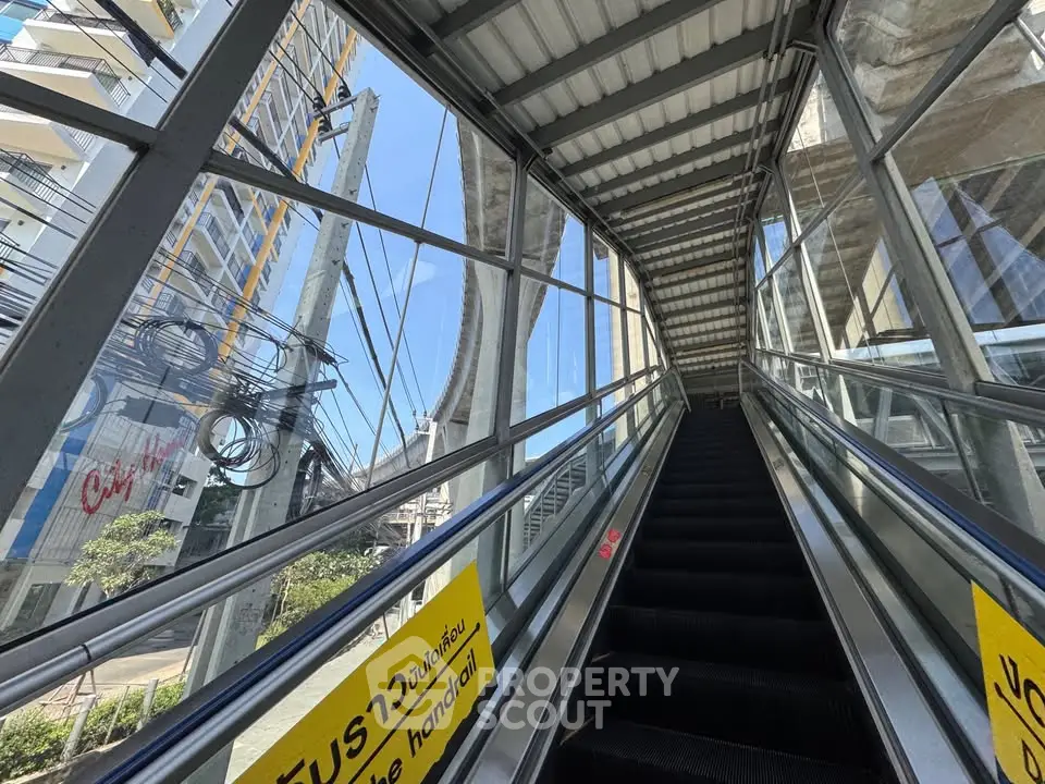 Modern building exterior with glass elevator and urban view, showcasing architectural design.