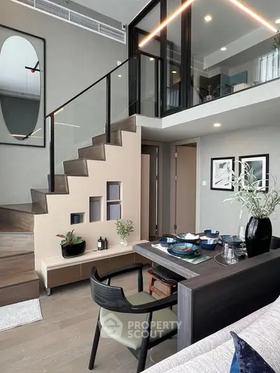 Modern duplex interior with stylish staircase and dining area, featuring elegant decor and open layout.