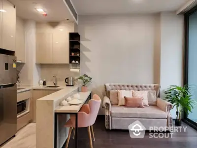 Chic open-plan living space with modern kitchen, stainless steel appliances, and cozy sitting area, perfect for urban living.