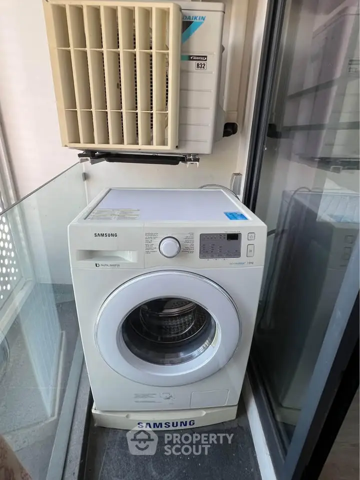 Compact balcony with washing machine and air conditioning unit, ideal for urban living.