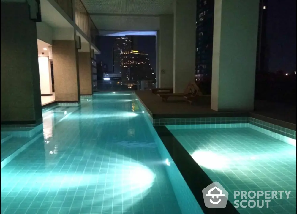 Luxurious rooftop pool with stunning city view at night, perfect for relaxation and entertainment.