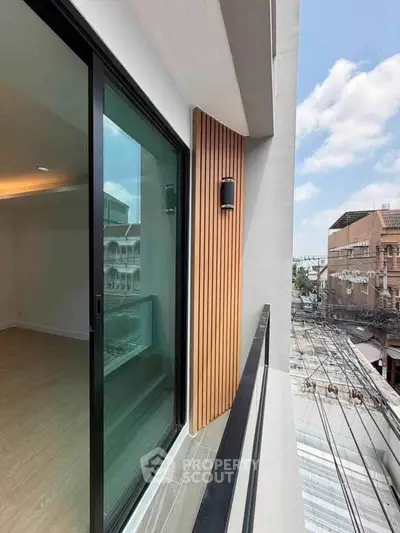 Modern balcony with sliding glass door and city view, perfect for urban living.