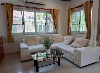 Spacious living room with elegant white sofa and large windows for natural light.