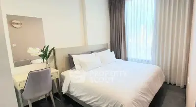 Modern bedroom with elegant decor and natural light, featuring a comfortable bed and stylish furnishings.