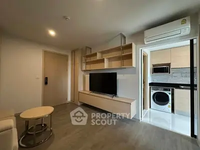 Modern living room with sleek wooden furniture and integrated kitchen appliances.