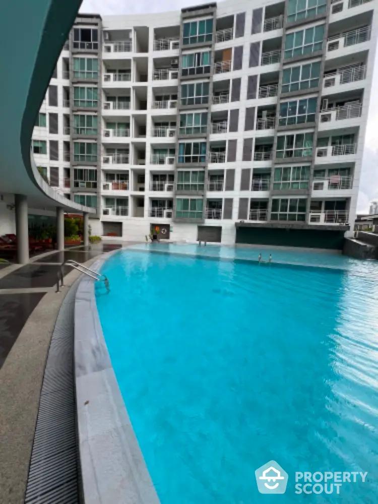 Luxurious residential building with stunning pool view and modern architecture.