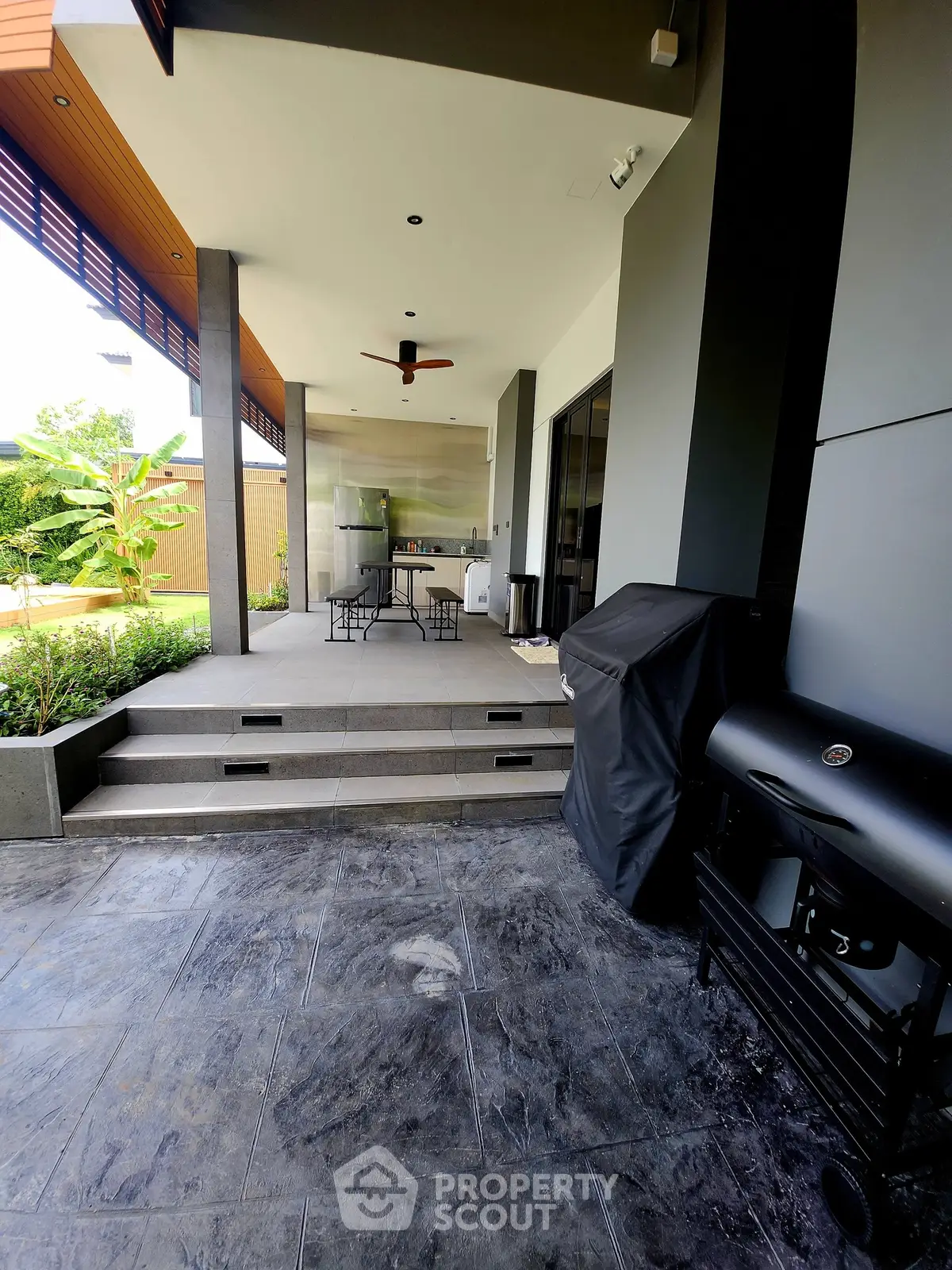 Modern outdoor patio with BBQ grill and stylish seating area
