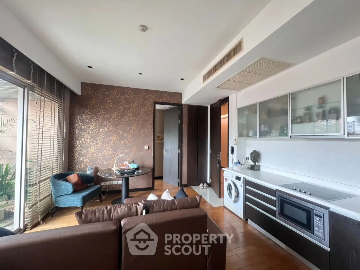 Modern open-layout living room with kitchen and balcony access