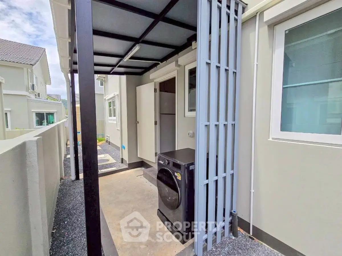 Modern exterior laundry area with washing machine in a stylish residential property.