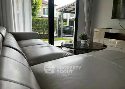 Modern living room with sleek leather sofa and garden view