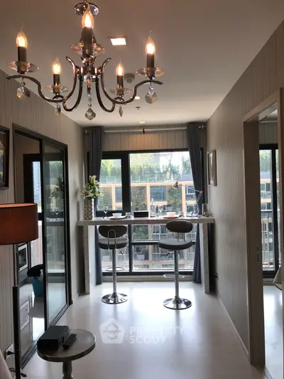 Modern living room with elegant chandelier and large windows offering a stunning view.