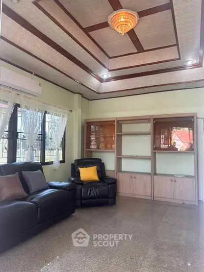 Spacious living room with elegant ceiling design and comfortable seating in a well-lit home.