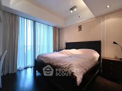 Spacious bedroom with large window and elegant furnishings