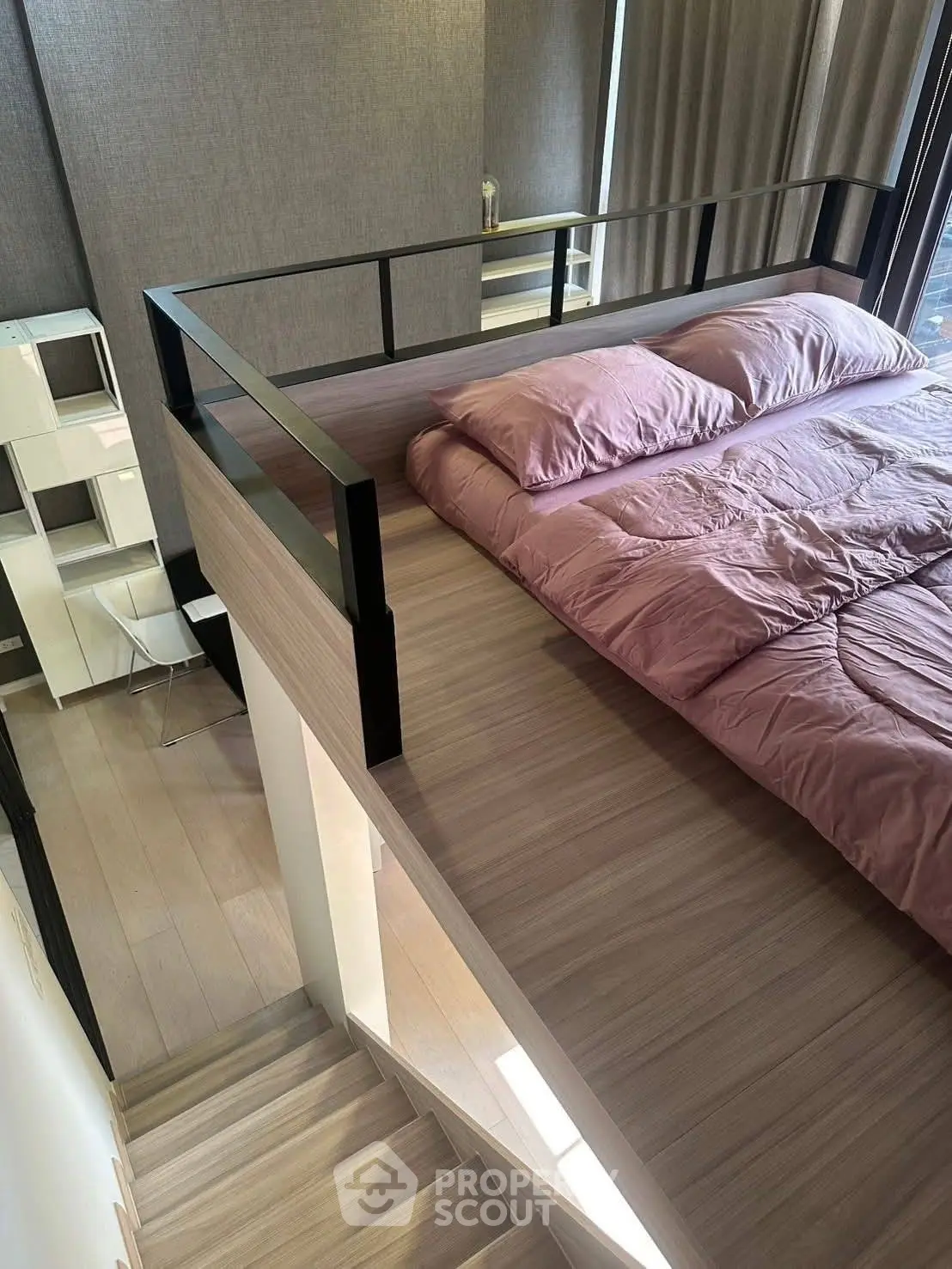 Modern loft bedroom with stylish railing and cozy bedding in a chic apartment