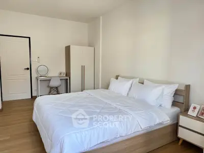Modern bedroom with cozy bed, minimalist decor, and natural light.