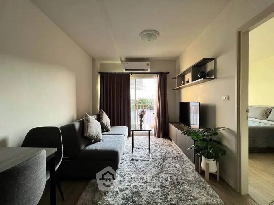 Cozy living room with modern decor and natural light, featuring a plush rug and stylish furniture.