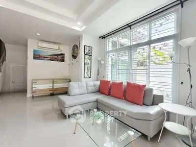 Spacious living room with modern decor and large windows