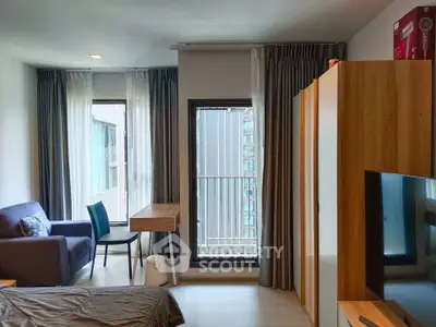 Modern studio apartment with cozy living area and large windows