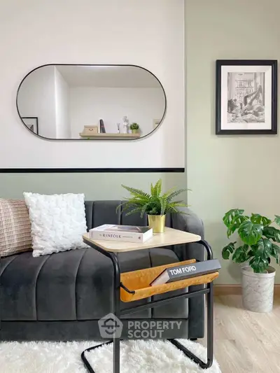 Stylish living room with modern decor, featuring a sleek sofa, elegant mirror, and lush green plants.