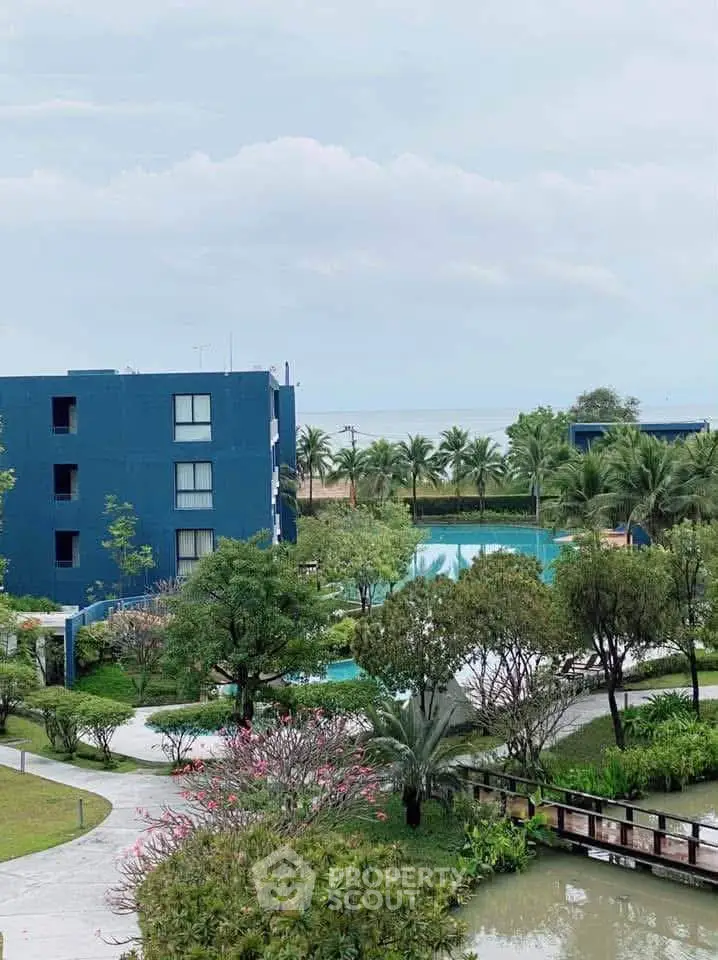 Stunning view of modern blue building with lush gardens and pool, perfect for serene living.