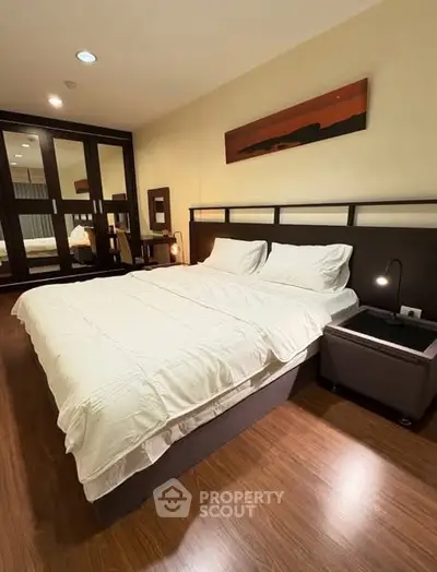 Spacious bedroom with modern furnishings and wooden flooring
