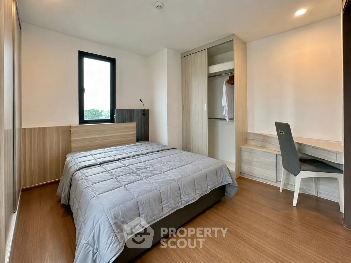 Modern bedroom with wooden flooring, cozy bed, and built-in wardrobe in a stylish apartment.