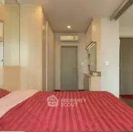 Cozy bedroom with red bedding and modern furnishings in a stylish apartment.
